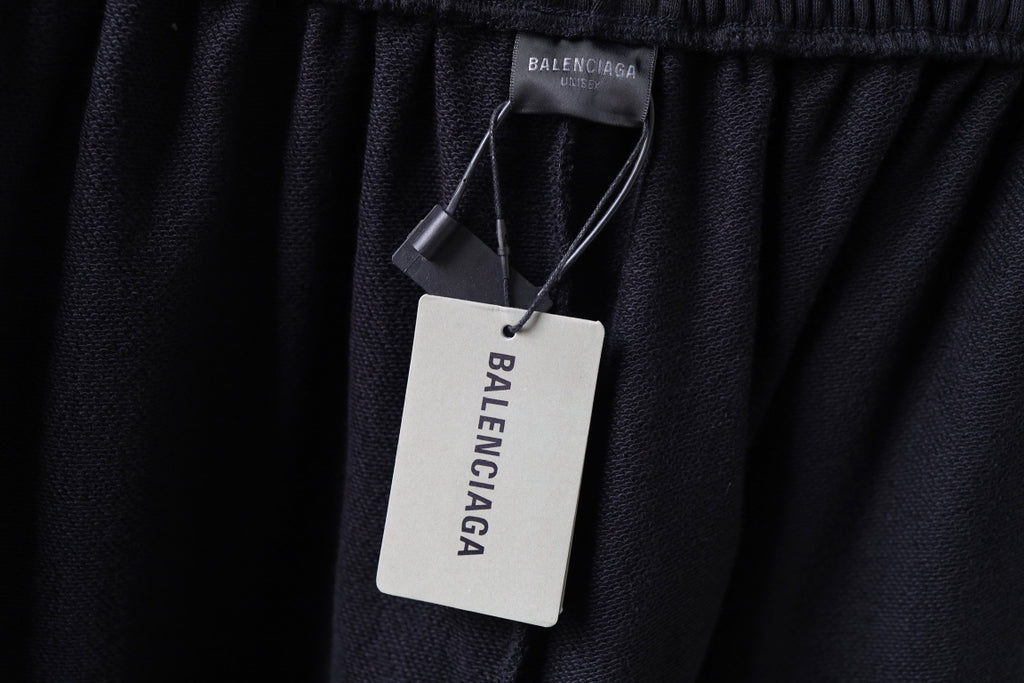 Balenciaga black shorts with hanging brand tag at waistband
