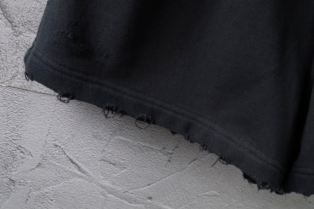 Black shorts hem with raw frayed edge and stitched trim