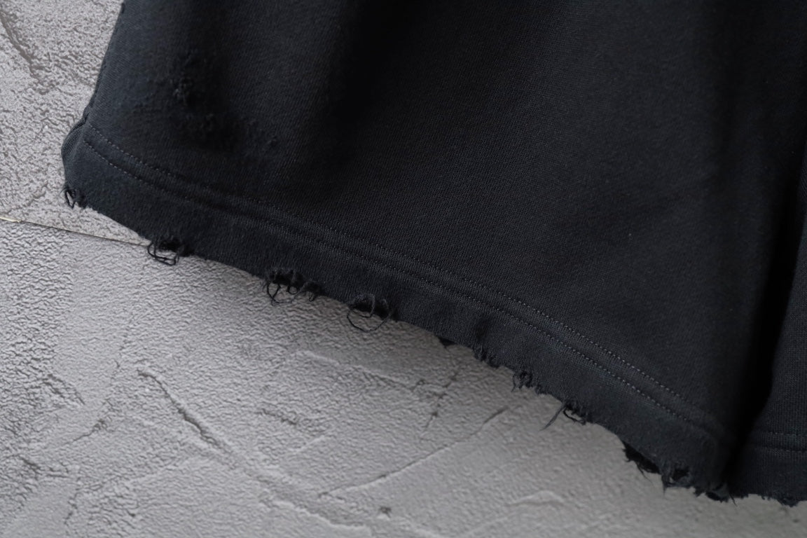 Black shorts hem with raw frayed edge and stitched trim