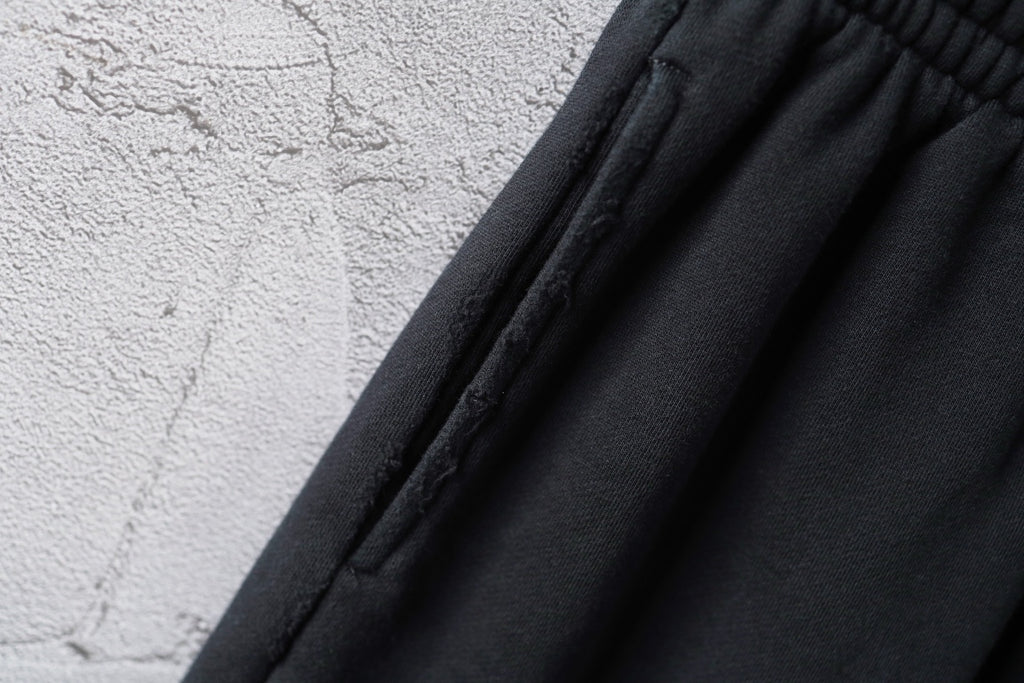 Black shorts fabric with vertical pleats near the waistband