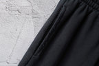 Black shorts fabric with vertical pleats near the waistband