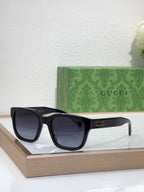 Gucci sunglasses with black frame and dark lenses, front angled view