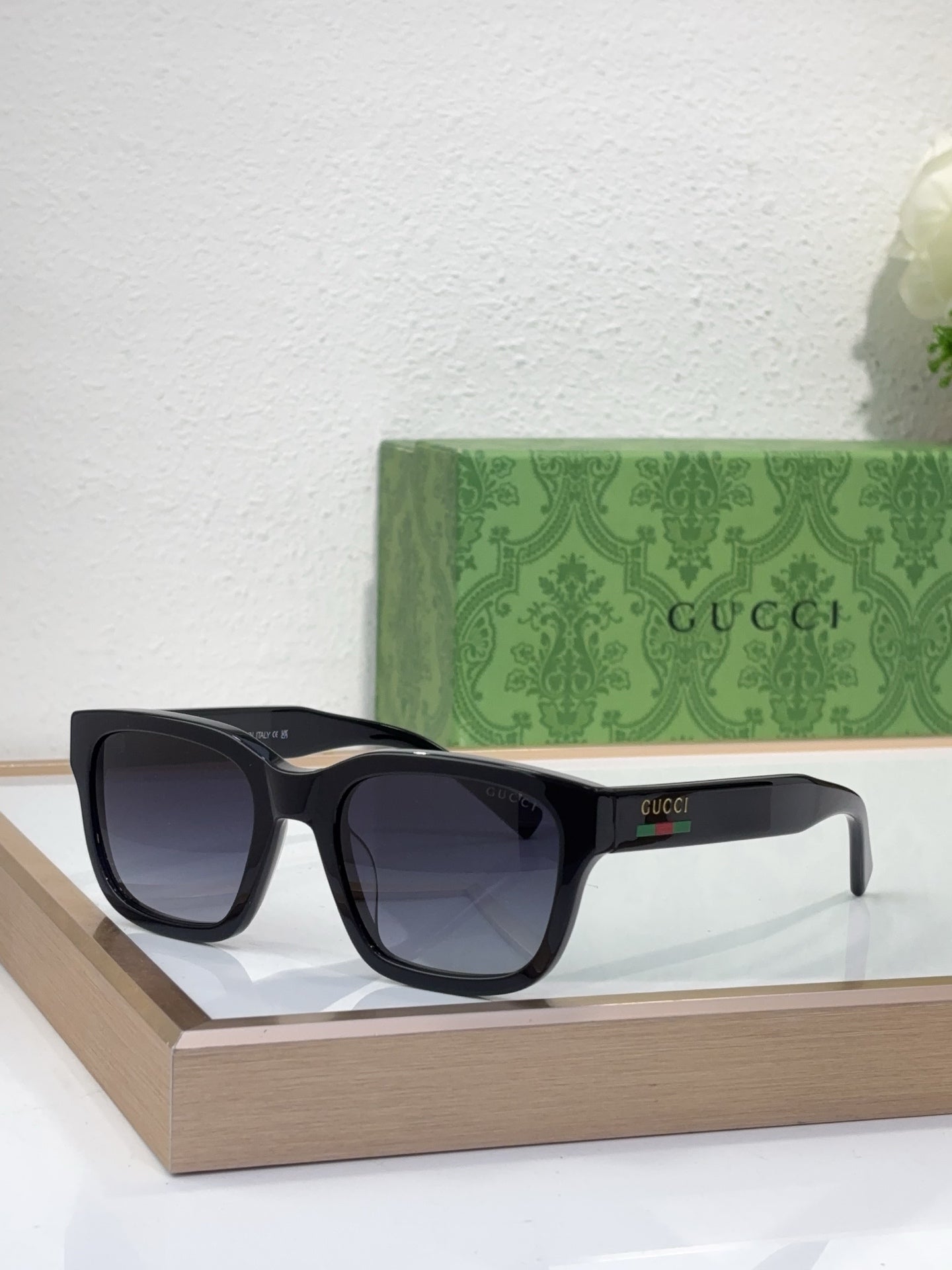 Gucci sunglasses with black frame and dark lenses, front angled view