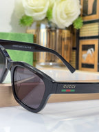 Gucci sunglasses with black frame and dark lenses, close-up side view