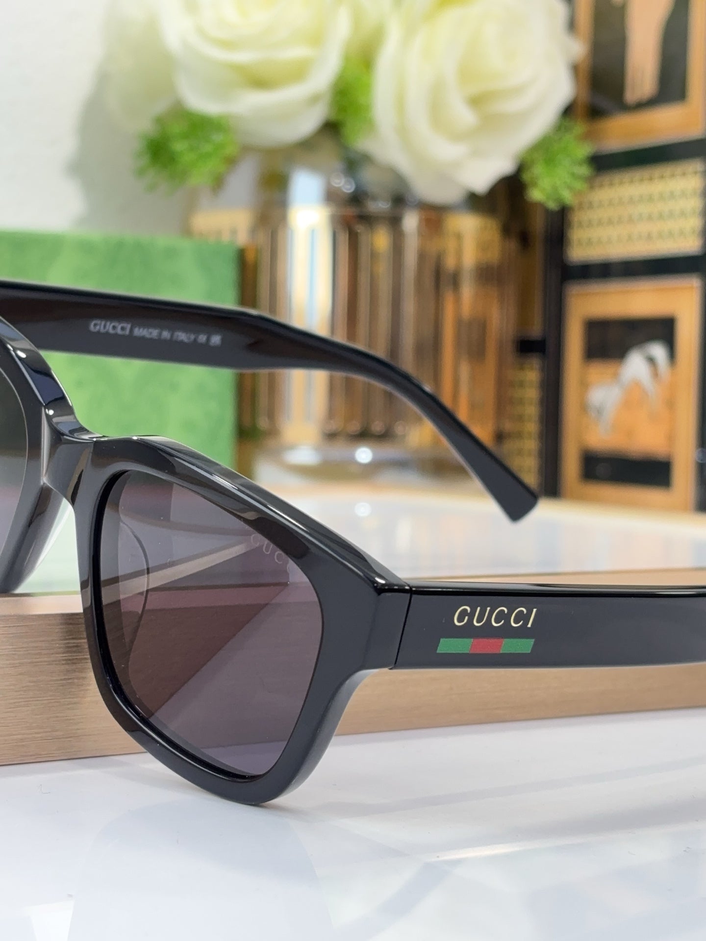Gucci sunglasses with black frame and dark lenses, close-up side view