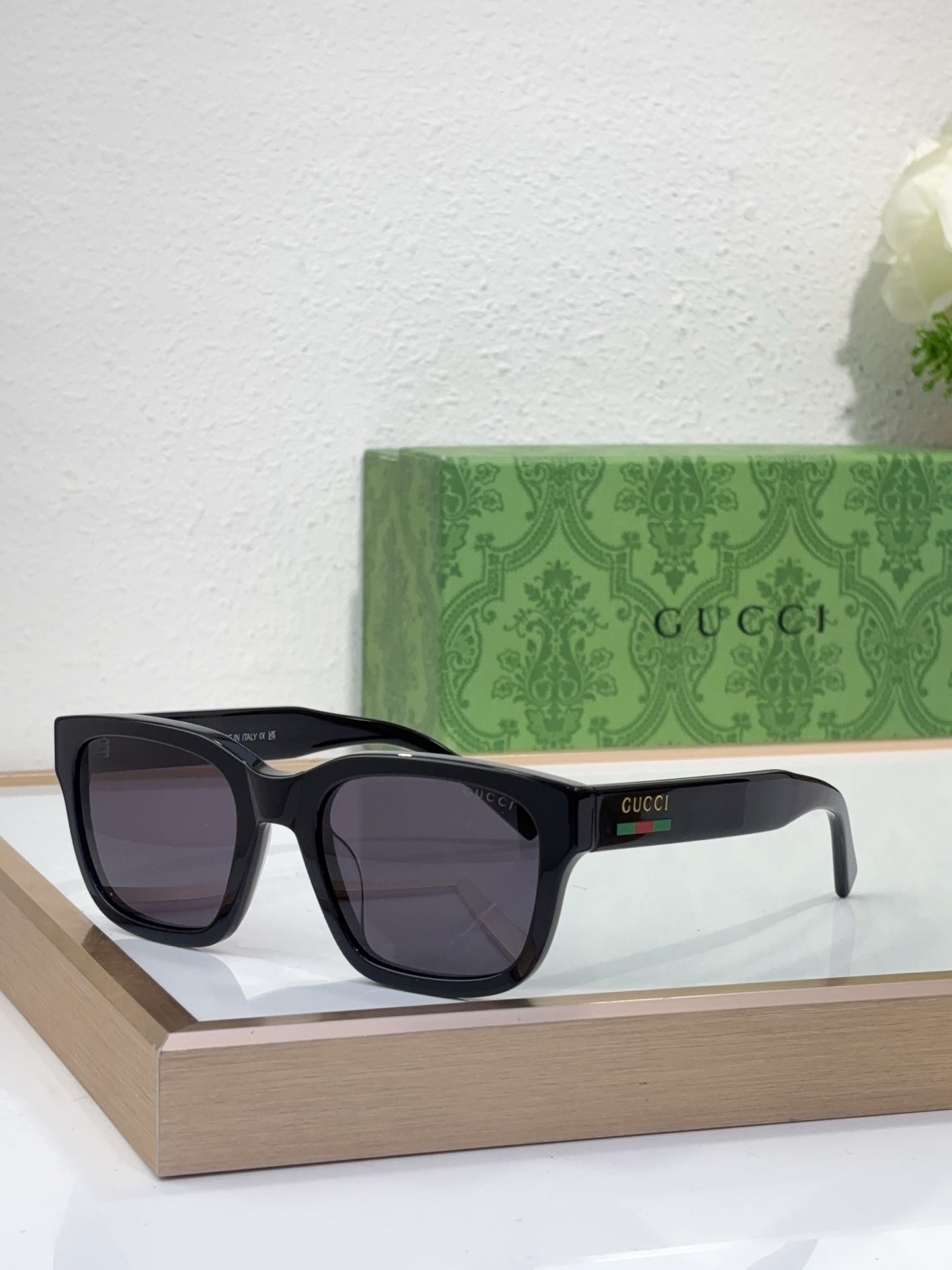 Gucci sunglasses with black frame and dark purple lenses, front view