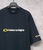 Dark Balenciaga T-shirt on hanger with yellow chest logo and right sleeve logo