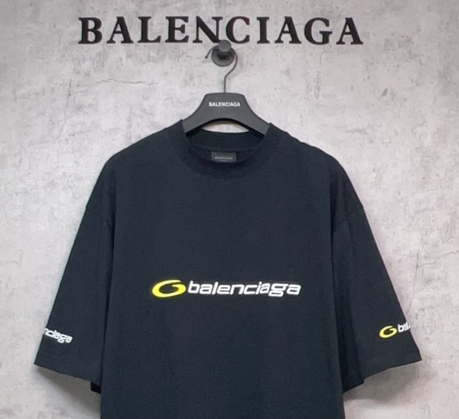 Dark crewneck Balenciaga T-shirt with yellow chest logo and left sleeve print