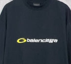 Dark T-shirt close-up with yellow Balenciaga logo across the chest