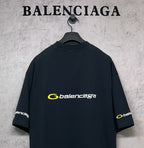 Dark Balenciaga T-shirt back view with yellow logo and sleeve logo patches