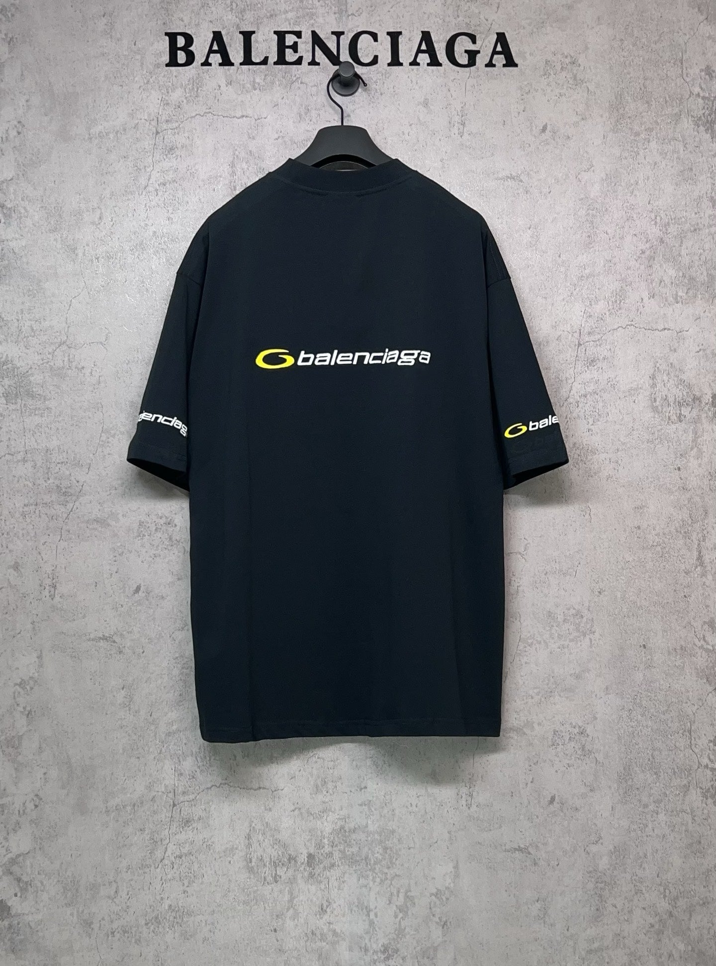 Dark Balenciaga crewneck T-shirt with yellow logo on chest and small sleeve logos