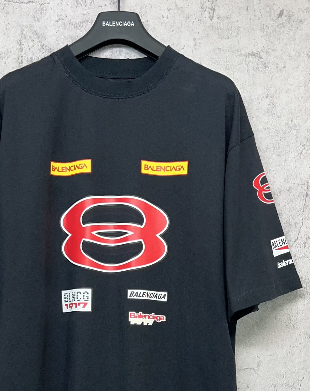 Dark navy short-sleeve T-shirt close-up with large red B graphic and small label prints.