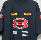 Dark navy short-sleeve T-shirt close-up with red B graphic and small stacked logo prints.