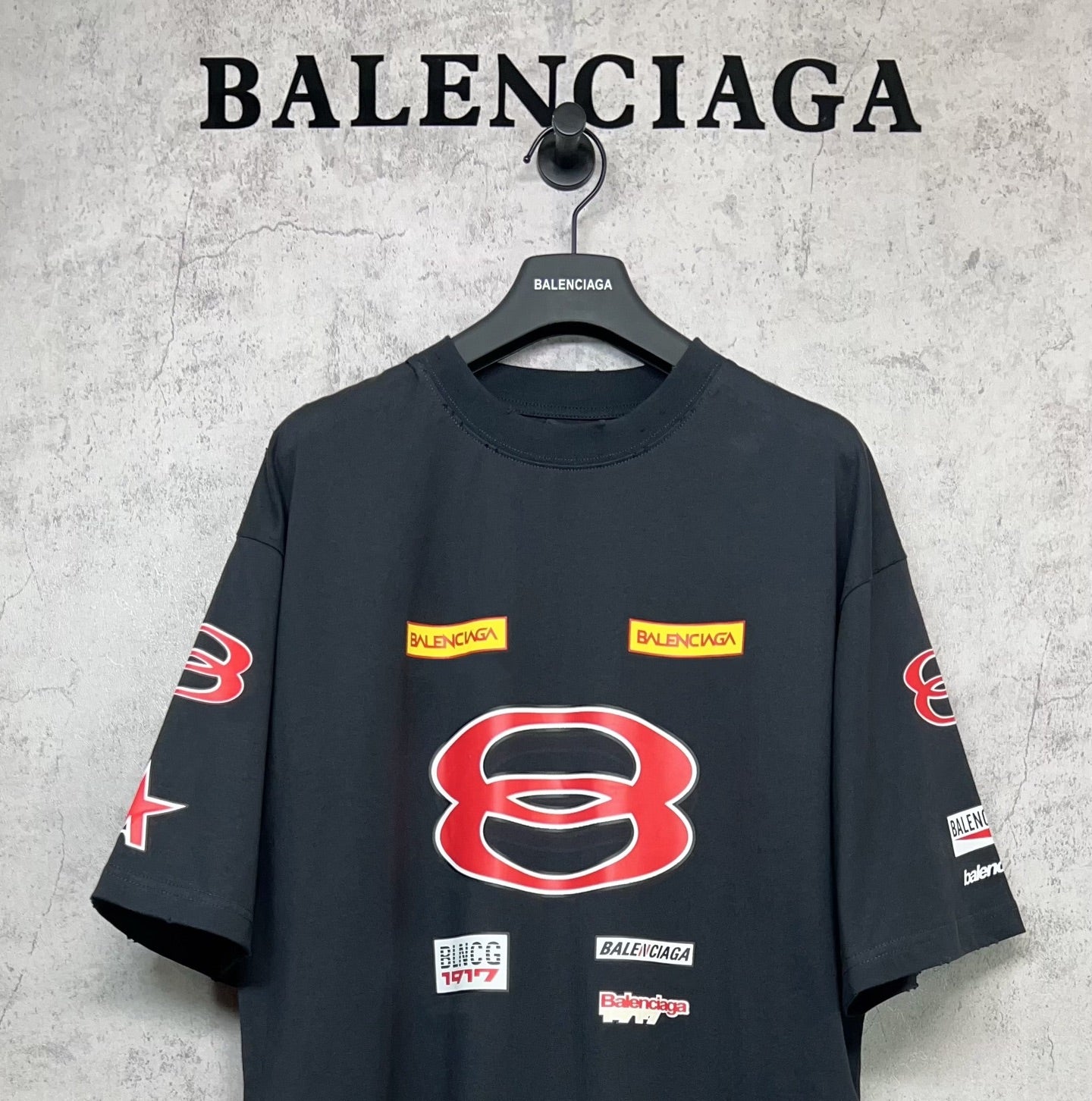 Dark navy short-sleeve T-shirt with large red B emblem and small logo labels.