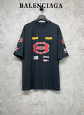 Dark navy short-sleeve T-shirt with large red B graphic and multicolor logo patches.