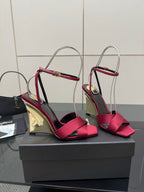 Women's heeled sandals with pink bow straps and mirrored gold heel, shown on display box