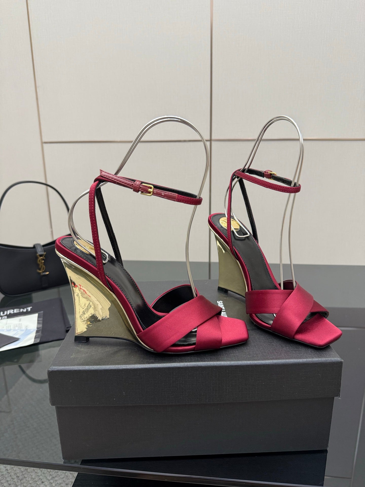 Women's heeled sandals with pink bow straps and mirrored gold heel, shown on display box