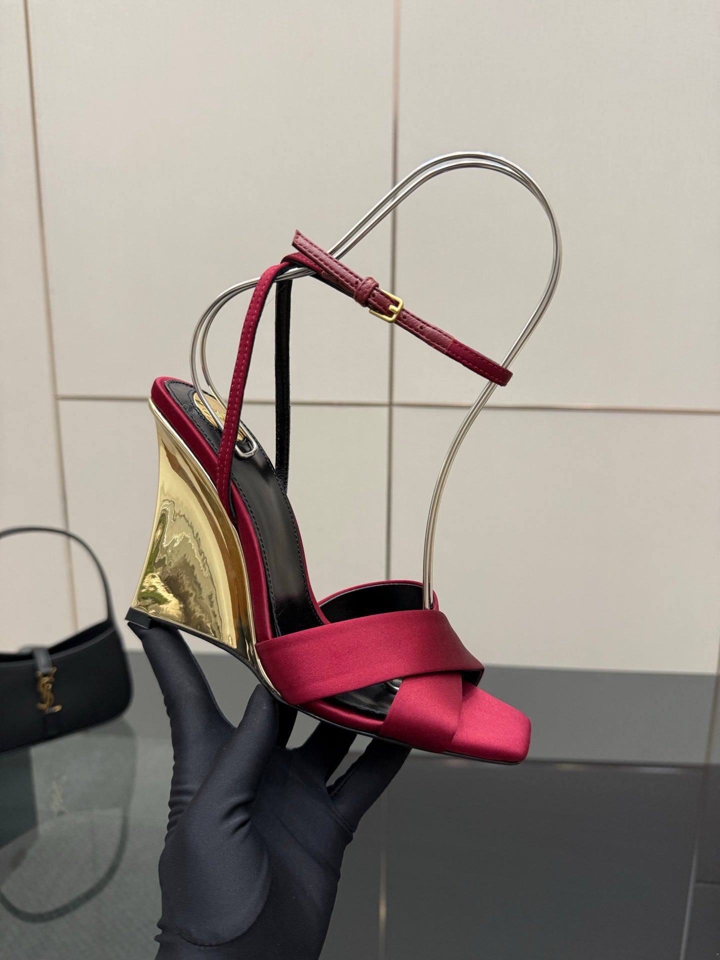 Close-up of women's heeled sandal with pink bow straps and mirrored gold heel