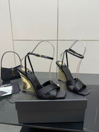 Black heeled sandals with open toe, crisscross straps, and clear ankle loops