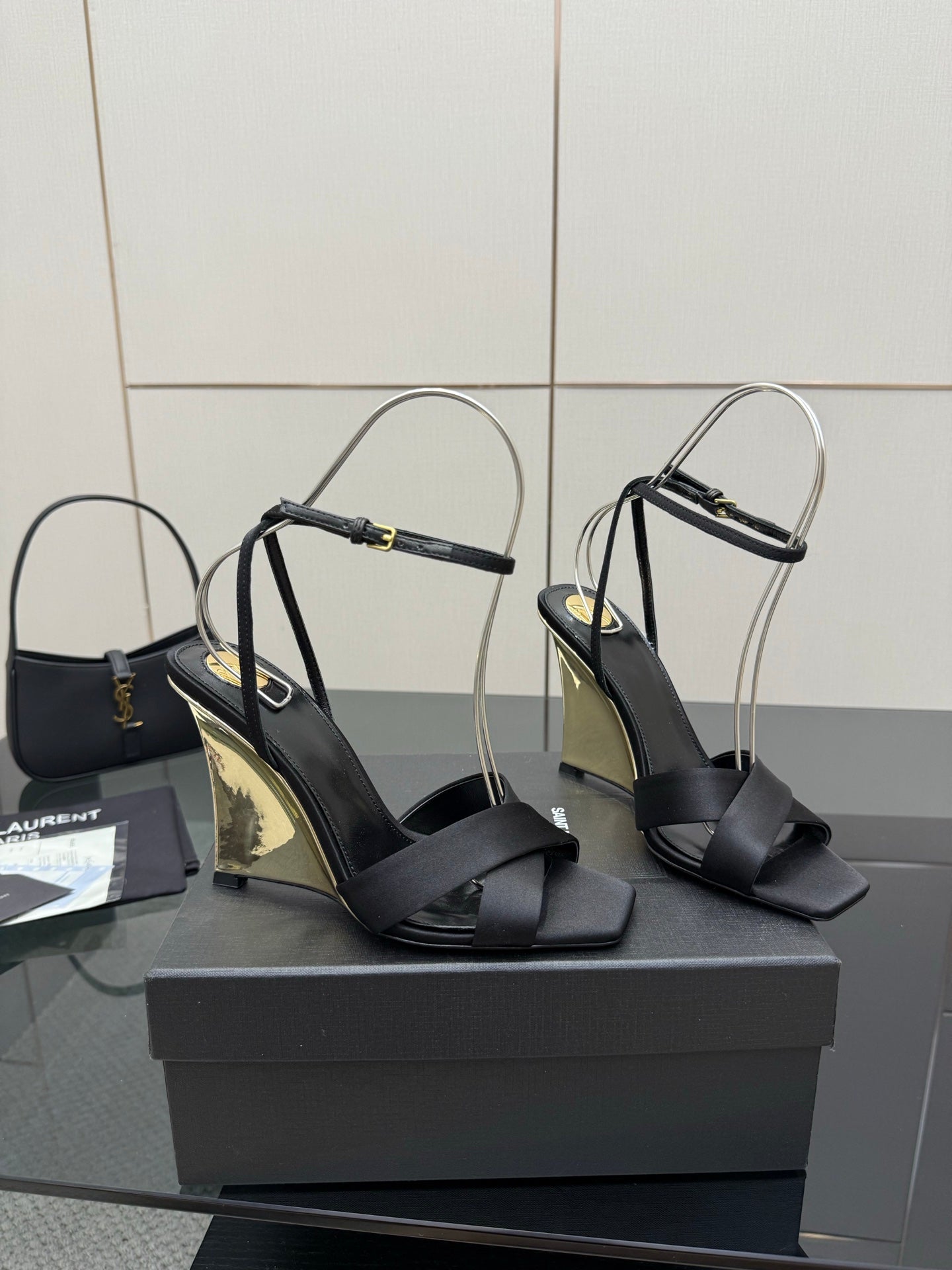 Black heeled sandals with open toe, crisscross straps, and clear ankle loops