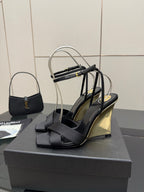 Black platform wedge sandal with open toe and stacked heel, bow-like strap detail