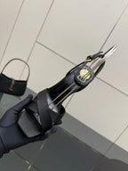 Black platform wedge sandal close-up showing front straps with gold logo bar accent