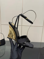 Black platform wedge sandal side view with gold sole panel and ankle strap