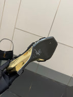 Black wedge sandal close-up of heel and gold-printed sole
