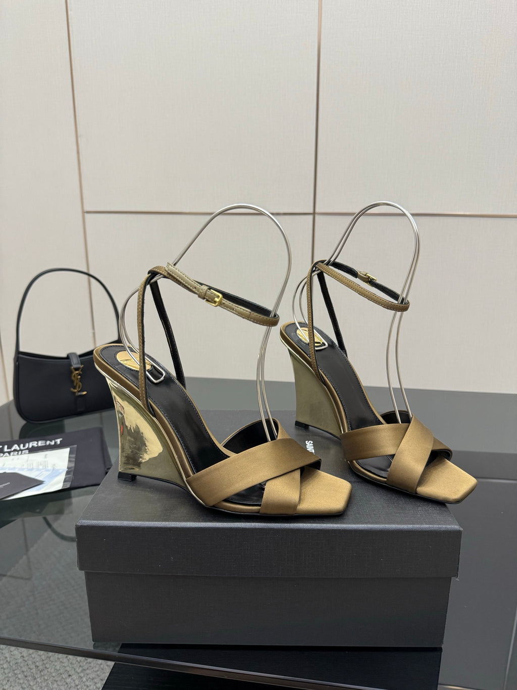 Pair of gold open-toe heeled sandals with silver ankle straps and black footbed