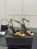 Pair of gold open-toe heeled sandals with silver ankle straps and black footbed