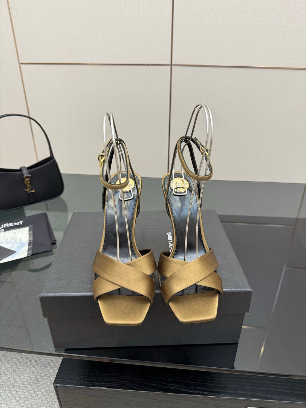 Open-toe heeled sandals with gold straps, black lining, and silver ankle straps