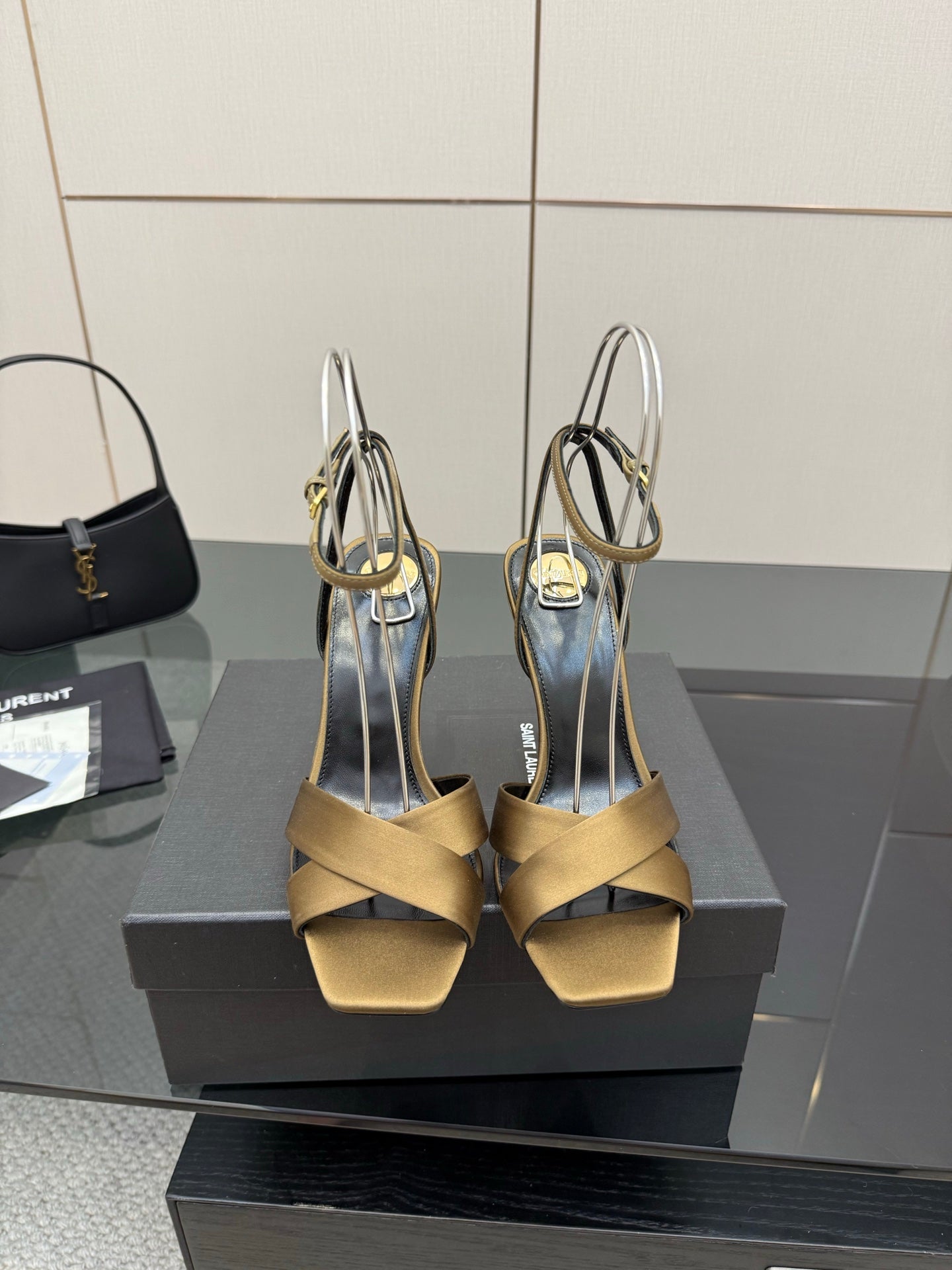 Open-toe heeled sandals with gold straps, black lining, and silver ankle straps