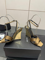 Gold open-toe heeled sandals with silver ankle straps and black low platform