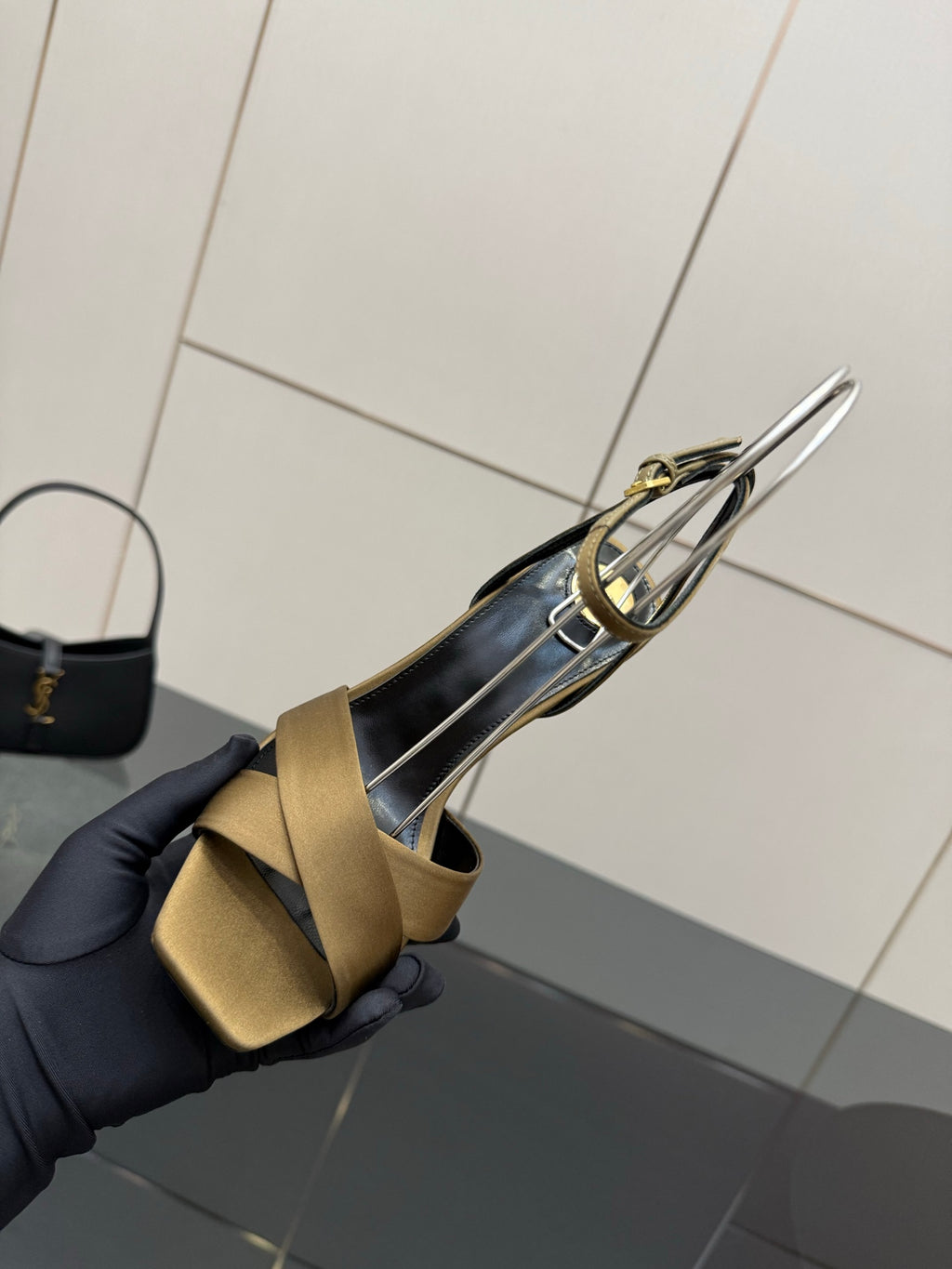 Gold open-toe heeled sandal with silver ankle strap detail and black lining