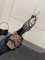 Women's high-heel sandal with leopard-print straps and clear loops, heel-and-toe close-up.
