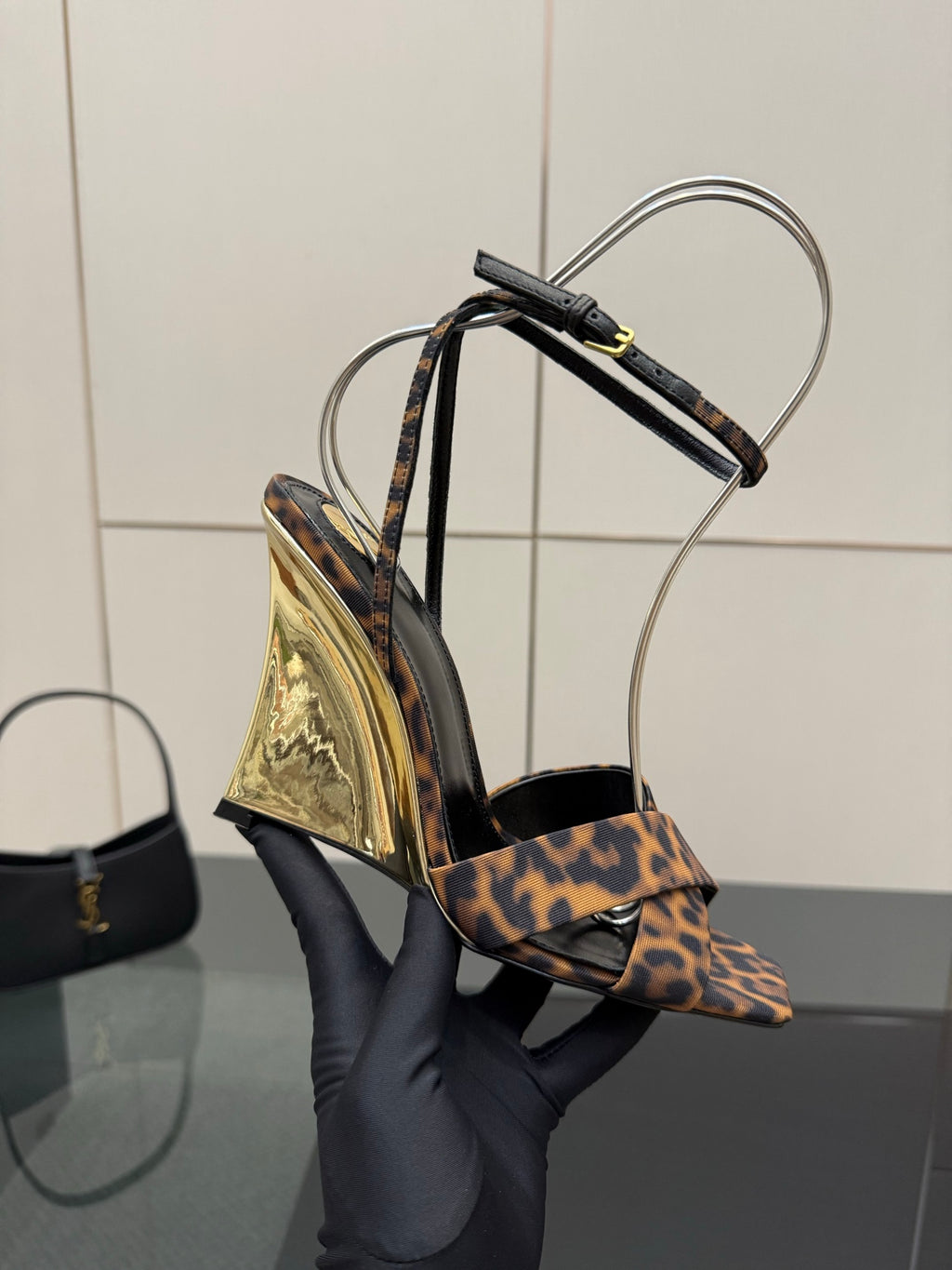 Women's high-heel sandals with leopard-print straps and clear ankle loops, close side view.