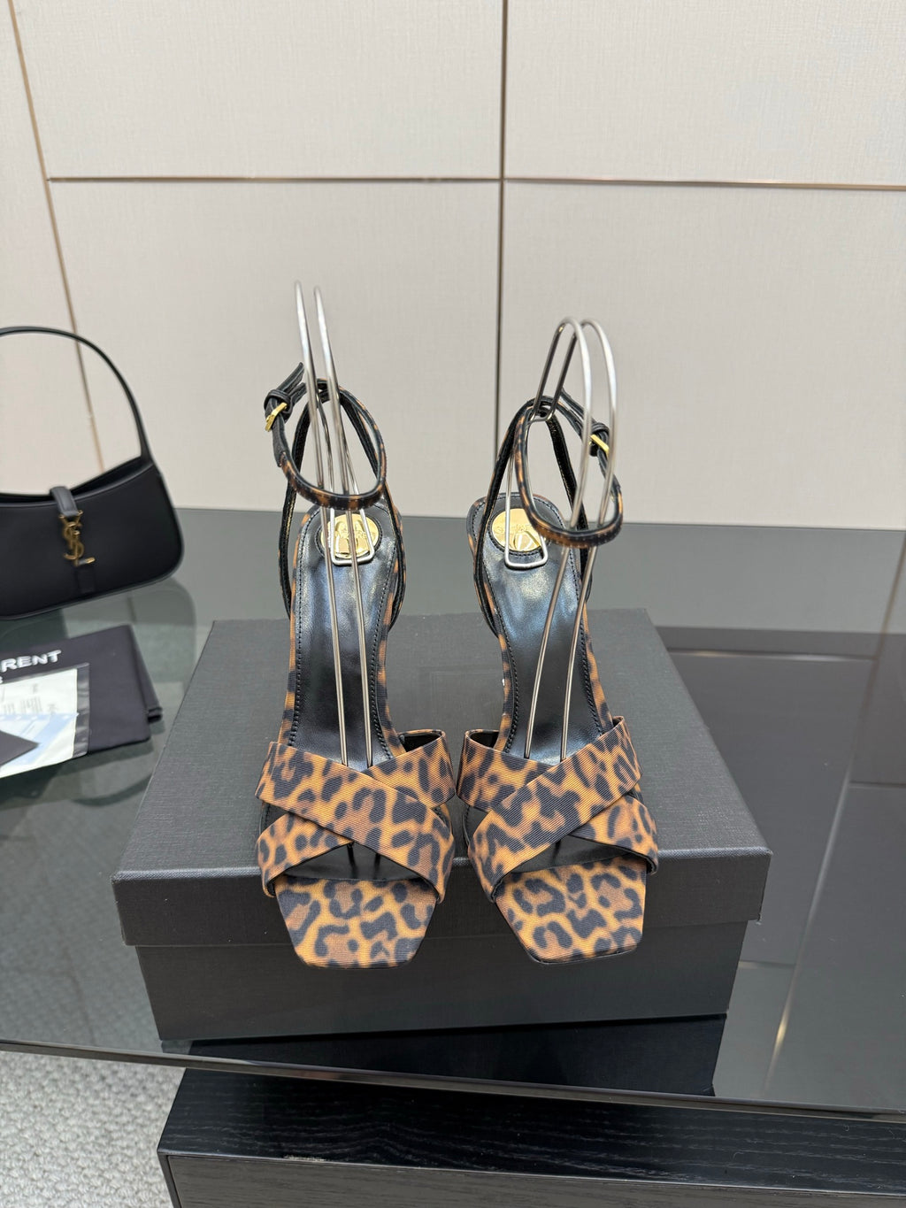 Women's high-heel sandals with leopard-print straps and clear loops, pair view.