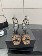 Women's high-heel sandals with leopard-print straps and clear loops, pair view.