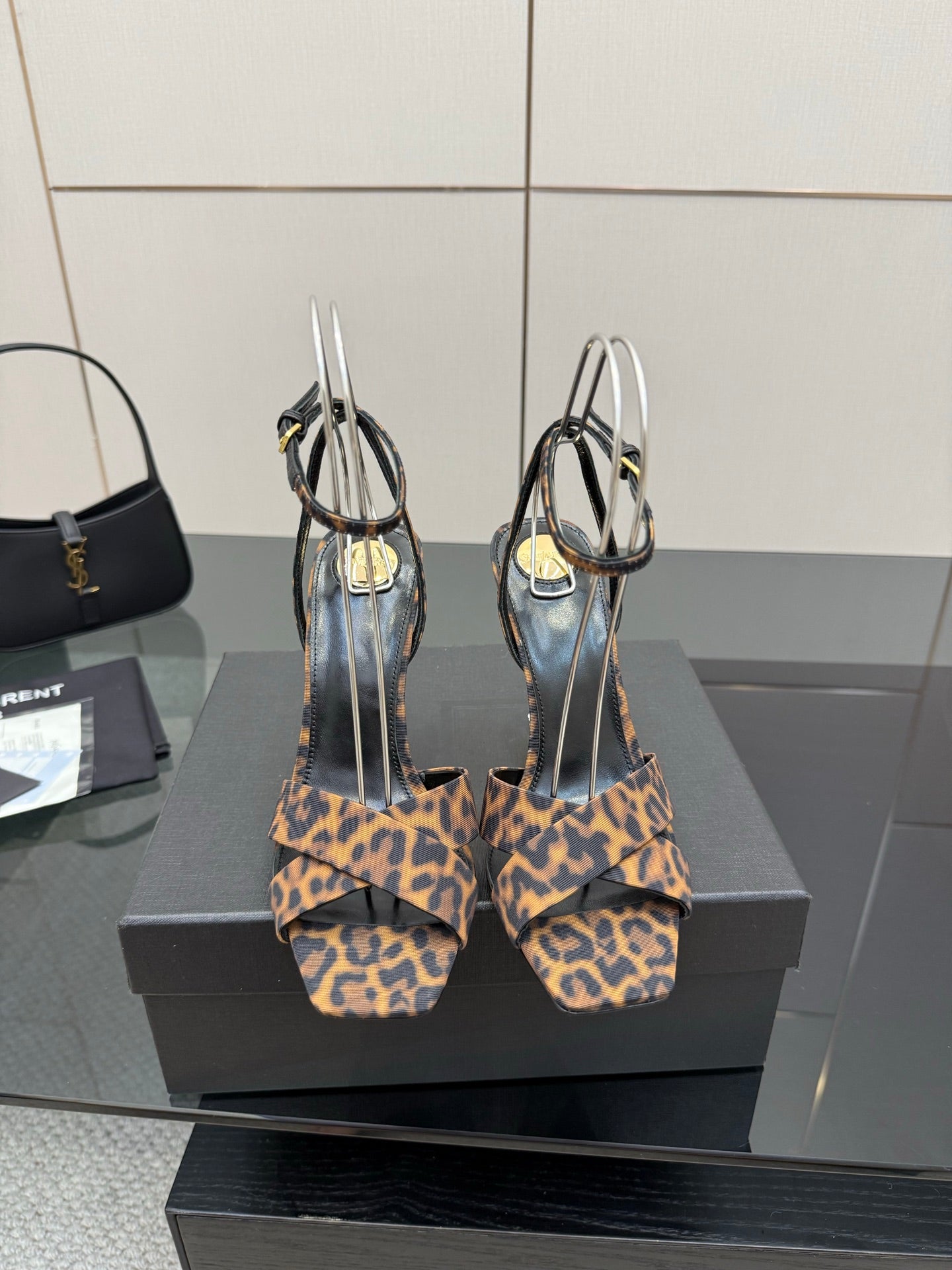 Women's high-heel sandals with leopard-print straps and clear loops, pair view.