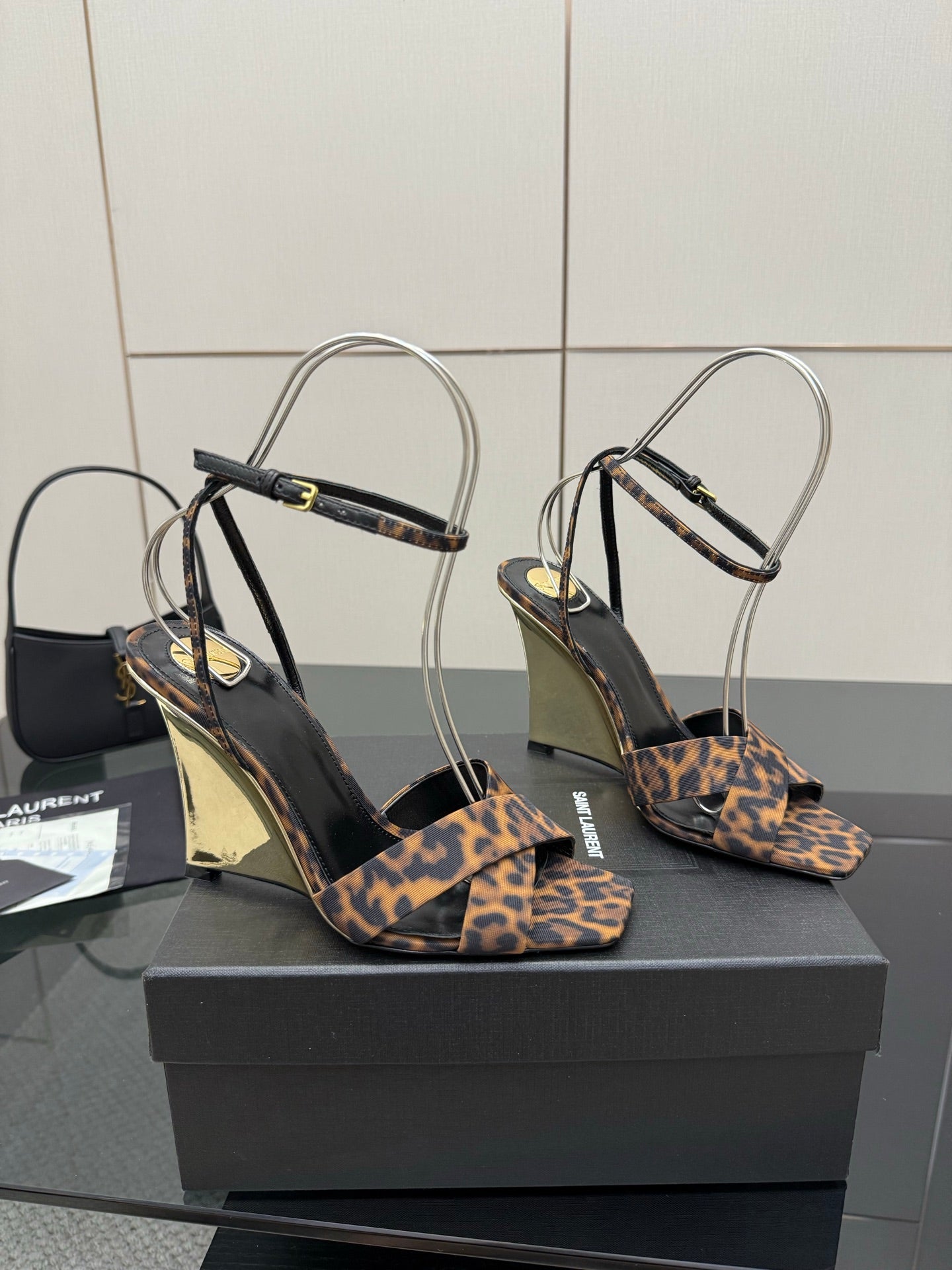 Women's high-heel sandals with leopard-print straps, clear ankle loops, wedge heel view.
