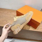 Hermes sneaker close-up, cream and light gray upper with thick ribbed outsole