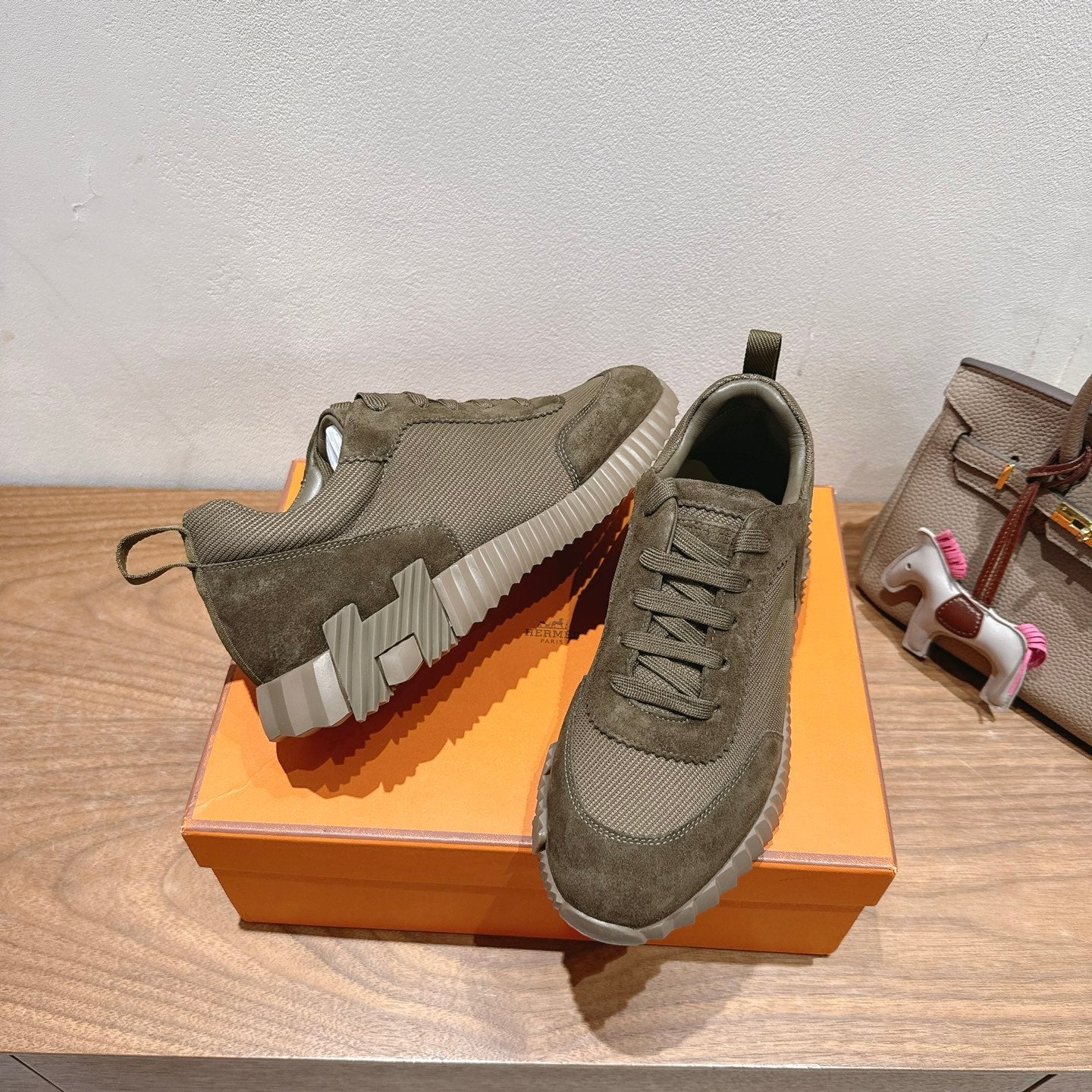 Hermes unisex sneakers showing profile: olive canvas upper, lace-up, rugged rubber outsole