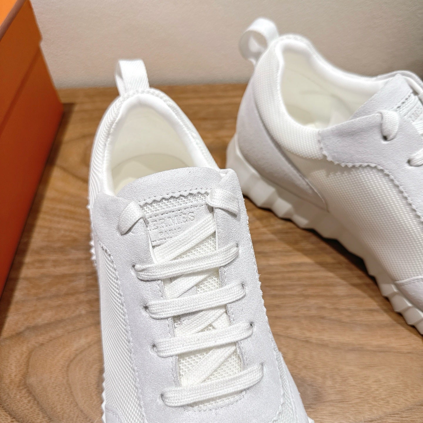 Hermes white unisex sneakers, close-up toe and laces, stitched panel details