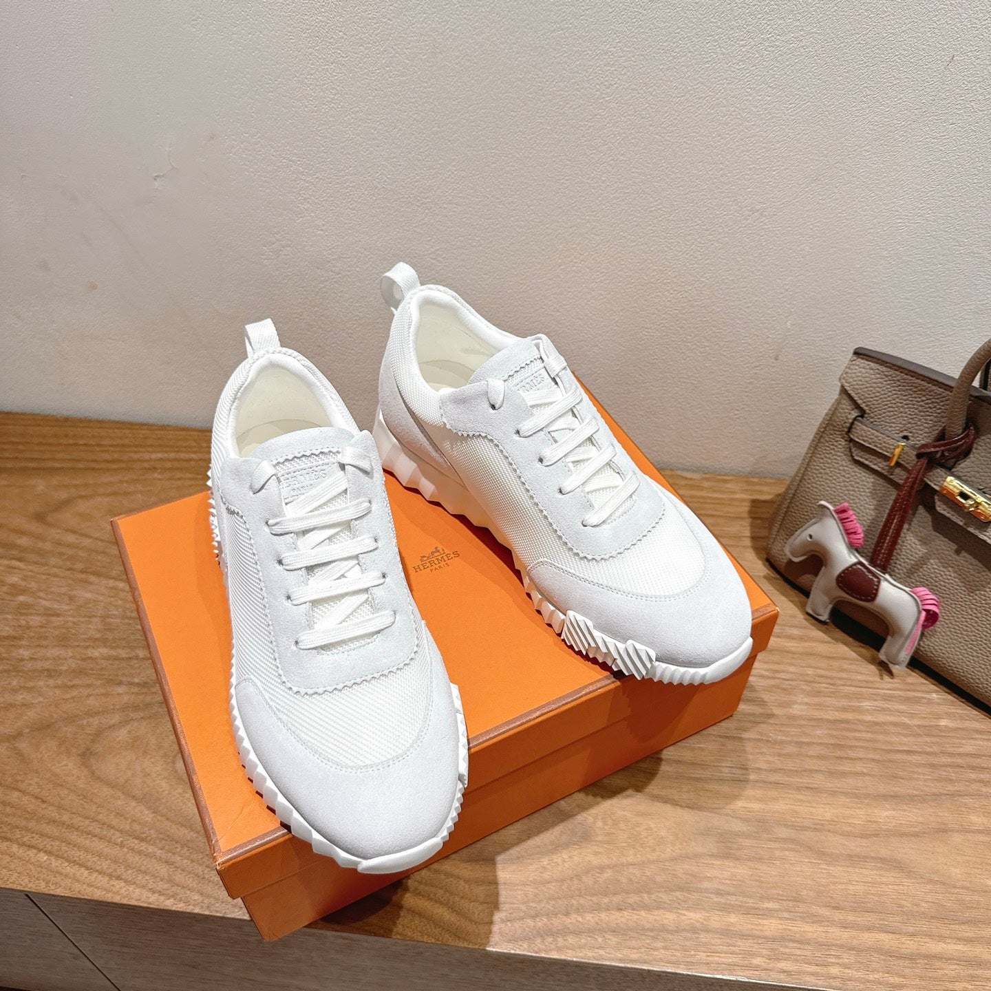 Hermes white unisex sneakers, front-and-side view, lace-up with cushioned sole