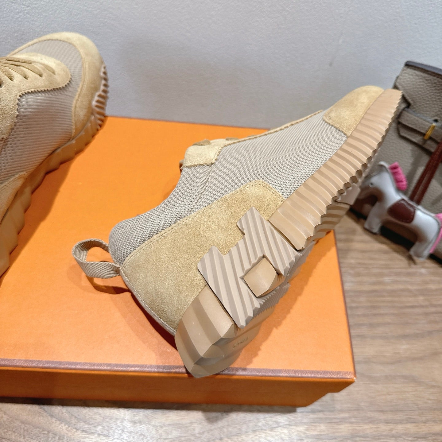Hermes sneaker outsole view, cream and gray uppers with ribbed sole tread