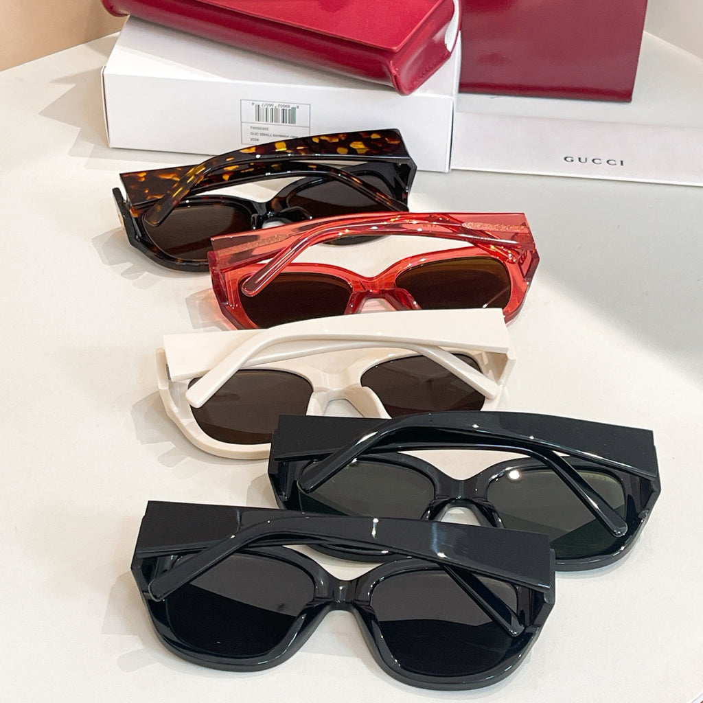 Assorted Gucci sunglasses with tortoiseshell, red, white, and black frames on display.