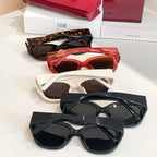 Assorted Gucci sunglasses with tortoiseshell, red, white, and black frames on display.
