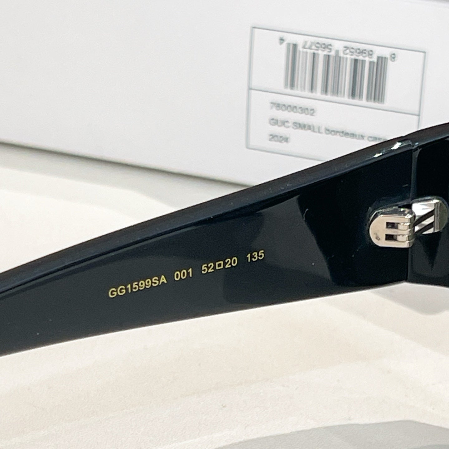 Black Gucci sunglasses temple with GG1599SA and size marking, near metal hinge.