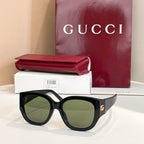 Black Gucci sunglasses with round lenses and thick acetate frames, with logo temples.