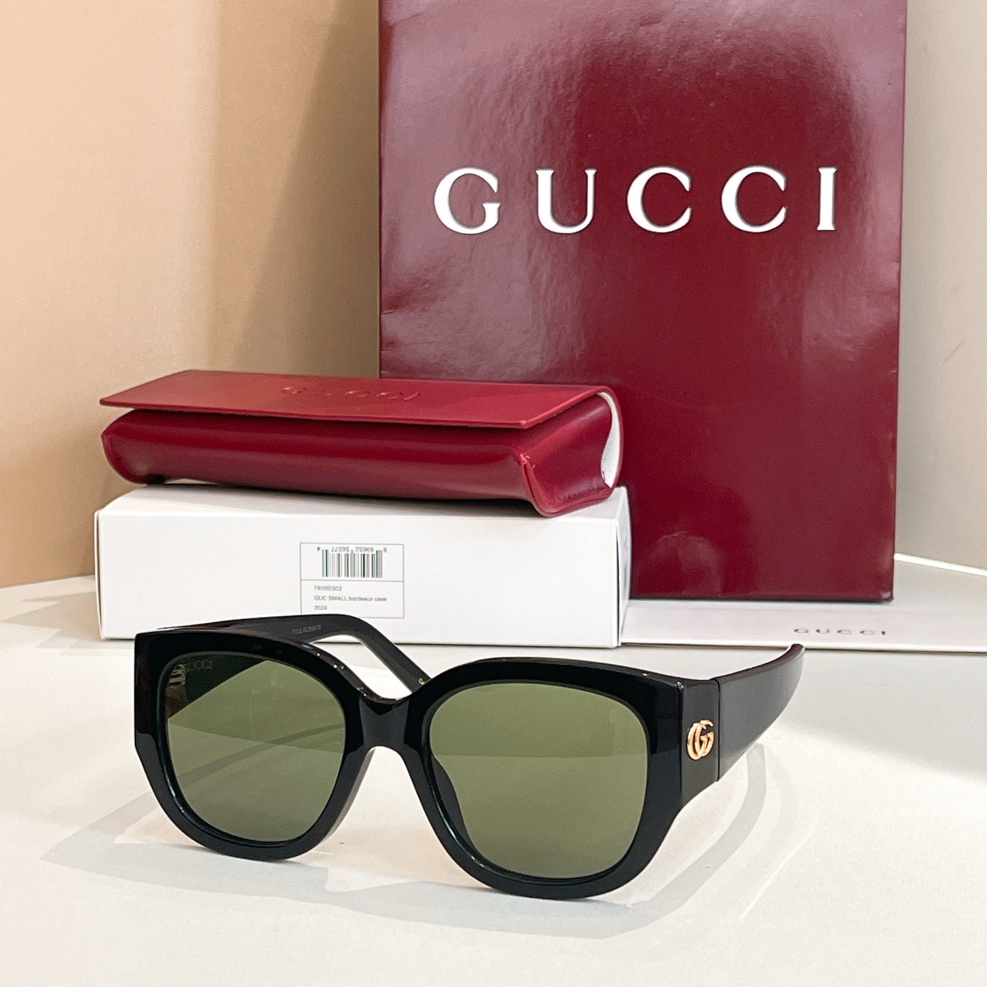 Black Gucci sunglasses with round lenses and thick acetate frames, with logo temples.